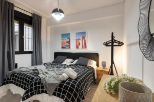 sypialnia z czarno-białym łóżkiem i krzesłem w obiekcie Marzana by Staynnapartments w mieście Bilbao