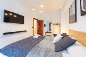 sypialnia z dużym łóżkiem z telewizorem na ścianie w obiekcie Marzana by Staynnapartments w mieście Bilbao
