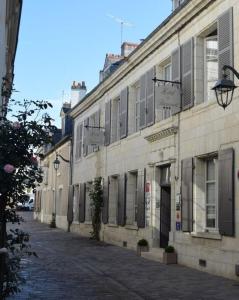 an old building on a street in a city at Hôtel de Biencourt in Azay-le-Rideau