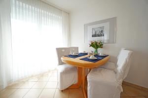 une salle à manger avec une table et des chaises blanches dans l'établissement Villa Madeleine Wohnung 6, à Bansin