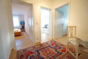 Cette chambre dispose d'un couloir avec un tapis. dans l'établissement Villa Madeleine Wohnung 6, à Bansin