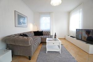 - un salon avec un grand canapé et une télévision dans l'établissement Villa Madeleine Wohnung 6, à Bansin