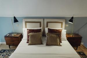 ein Schlafzimmer mit einem großen weißen Bett mit Kissen in der Unterkunft Casa Amora STUDIOS in Lissabon