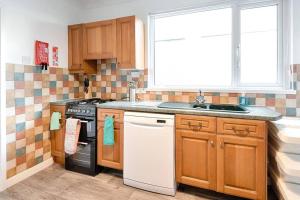 a kitchen with a stove and a sink and a window at Great base in Swansea! in Swansea