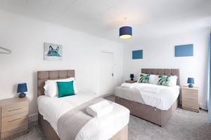 a bedroom with two beds and a dresser and sidx sidx sidx sidx at Great base in Swansea! in Swansea
