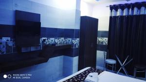 a room with a bed and a tv in a room at Hotel Ravi Palace Agra in Agra