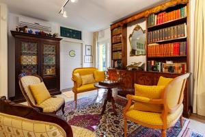 een woonkamer met gele stoelen en een boekenplank bij Le Ginestre in Massa
