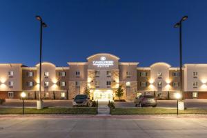 un gran edificio con coches estacionados en un estacionamiento en Candlewood Suites New Braunfels, an IHG Hotel, en New Braunfels