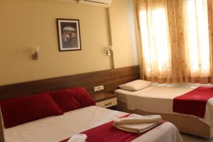 a hotel room with two beds and a window at Dove Apart Hotel in Fethiye