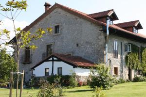 a large stone house with a red roof at Casona Camino de Hoz in Anero +37 photos