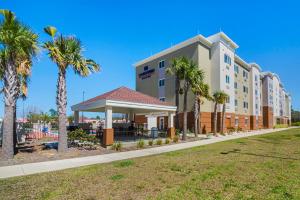 ein Hotel mit Palmen und einem Pavillon in der Unterkunft Candlewood Suites - Pensacola - University Area, an IHG Hotel in Pensacola