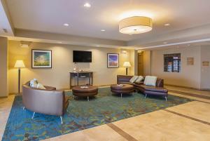 a lobby with couches and chairs and a flat screen tv at Candlewood Suites - Pensacola - University Area, an IHG Hotel in Pensacola