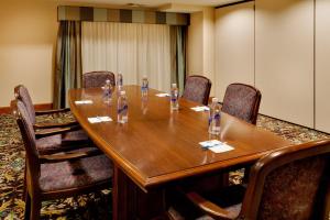 ハリスバーグにあるStaybridge Suites Harrisburg-Hershey, an IHG Hotelの大きな木製テーブルと椅子付きの会議室