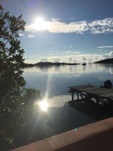 un muelle en un lago con el sol reflejándose en el agua en Naniqui Cottage - Only Adults Relax - Only Parking Golf Car, en Culebra