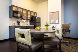 a kitchen with a table and chairs in a room at Candlewood Suites Sidney by IHG in Sidney