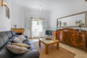 a living room with a leather couch and a mirror at Holiday Home Ribot in Ariany