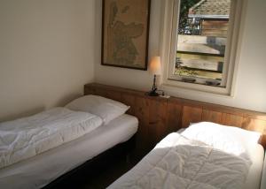 dwa łóżka w pokoju z oknem w obiekcie Rekerlanden 257 w mieście Schoorldam