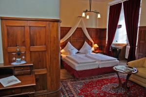 a hotel room with a bed and a couch at Hotel Schloss Edesheim in Edesheim