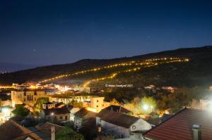 Una ciudad de noche con luces en una montaña en Guest House Ostojić, en Međugorje