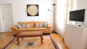 een woonkamer met een bank en een tv bij Apartment Villa Penzing in Wenen