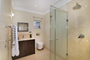 a bathroom with a shower and a sink at Sandown Guest House in Johannesburg