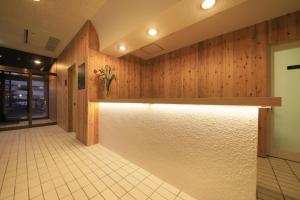 vestíbulo con paredes revestidas de madera y mostrador de recepción en Kokotel Hakodate, en Hakodate
