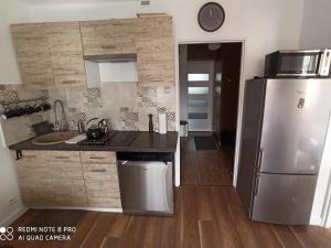 a kitchen with a stainless steel refrigerator and wooden floors at Apartament Pod sanockim zamkiem in Sanok