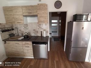 a kitchen with a stainless steel refrigerator and wooden floors at Apartament Pod Sanockim Zamkiem in Sanok