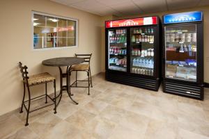 a restaurant with a table and chairs and a drink cooler at Candlewood Suites San Antonio NW Near SeaWorld, an IHG Hotel in San Antonio