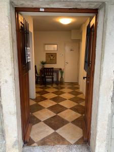 an open door to a hallway with a checkered floor at Viktor Rooms in Kotor