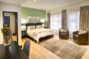 1 dormitorio con 1 cama, mesa y sillas en Sandown Guest House, en Johannesburgo