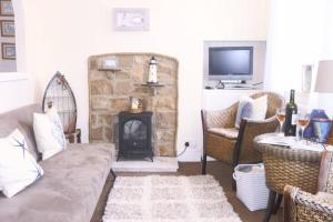 a living room with a couch and a fireplace at Kikas Cottage, Rear 89 Church Street, White Horse Yard in Whitby