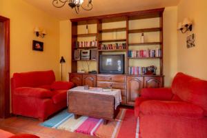 a living room with two red couches and a tv at Casa Nimar in El Paso