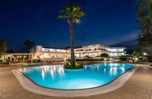 a large pool with a palm tree in front of a building at Sabina Hotel in Theologos
