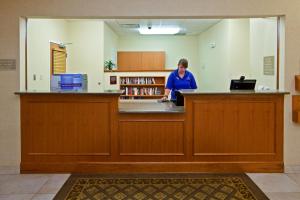 una mujer parada en un mostrador en una biblioteca en Candlewood Suites Louisville North, an IHG Hotel en Clarksville