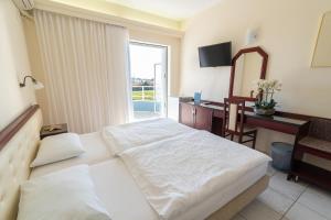 Postel nebo postele na pokoji v ubytování Dionisos Hotel