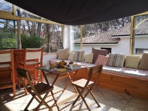 une terrasse avec un canapé, une table et des chaises dans l'établissement VILLA FLEUR DES PINS 6 PERSONNES 140m2 PETIT NICE, à Gujan-Mestras