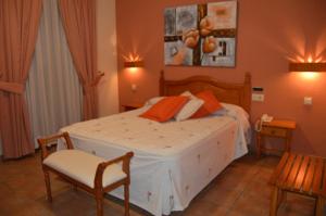 a bedroom with a large bed and a chair at HOTEL RURAL HIDALGO in Torreperogil