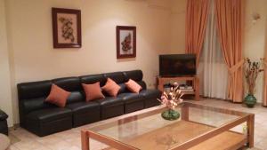 a living room with a black leather couch and a coffee table at HOTEL RURAL HIDALGO in Torreperogil