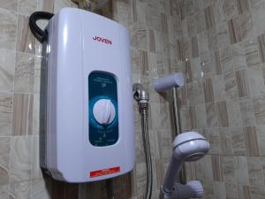 a white water heater in a shower in a bathroom at Clark-Pad Inn, Angeles City in Angeles