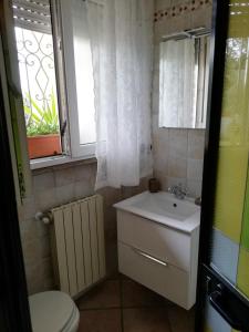 チンクアレにあるVilletta Marina Verde Cinqualeのバスルーム(洗面台、トイレ付)、窓が備わります。