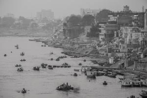 um grupo de barcos em um rio com edifícios em Dwivedi Hotels Hotel Elena em Varanasi