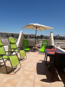 a group of chairs and tables and an umbrella at Studio Naturiste "SUNSHINE" Héliopolis FG 14 in Cap d'Agde