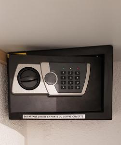un horno microondas con mando a distancia en la pared en Studio Naturiste "SUNSHINE" Héliopolis FG 14 en Cap d'Agde