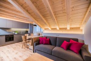 a living room with a couch with red pillows at Toninghof in Dobbiaco