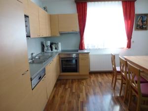 a kitchen with a sink and a table with chairs at Ferienhaus Teigi in Wagrain