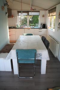 a kitchen with a white table and chairs in it at Rekerlanden 195 in Schoorldam