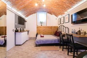 a room with a bed and a table and a kitchen at UNDERGROUND Jacuzzi Rooms in Krakow