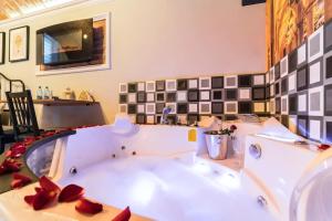 een groot wit bad in een badkamer met rode rozen bij UNDERGROUND Jacuzzi Rooms in Krakau