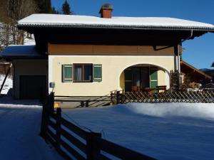 dom w śniegu z płotem w obiekcie Ferienhaus Teigi w mieście Wagrain